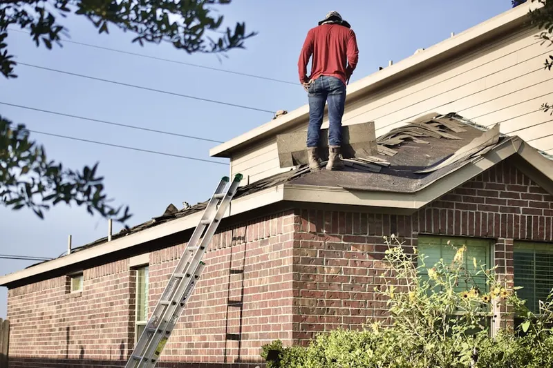 Professional roofer working on a residential roof in Teterboro
